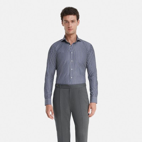 پیراهن یقه‌دار کلاسیک و آستین بلند Vakko که با طرح‌های راه راه آبی و سفید سرمه‌ای، پارچه‌های نخی و برش‌های راحت متمایز است، دارای دکمه‌ای تمام قد است.